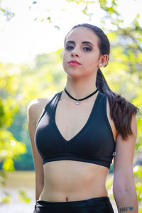 Portrait of young woman wearing sports bra at park