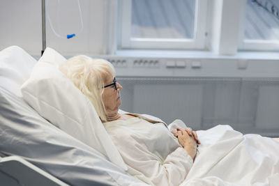 Senior woman lying in hospital bed