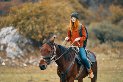 Young woman riding horse