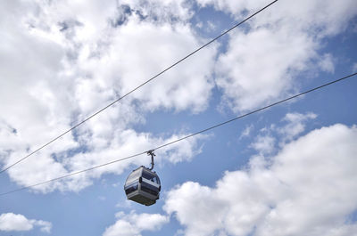 Low angle view of overhead cable cars against sky