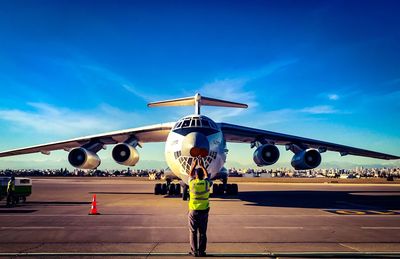 Rear view of man on airplane against sky