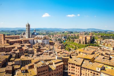 Aerial view of cityscape against blue sky