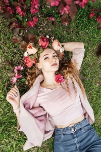 High angle portrait of woman lying on grass outdoors