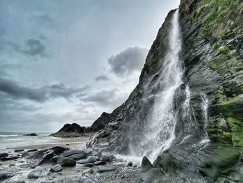 Scenic view of waterfall against sky