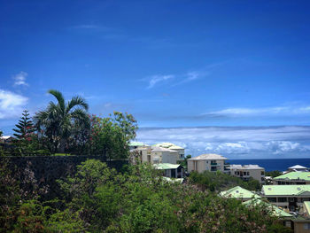 View of townscape by sea against blue sky