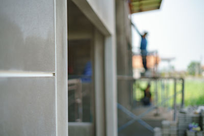 Man standing by railing against building