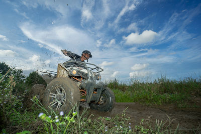 Atv on field against sky