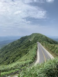 Empty road along landscape and mountains against sky