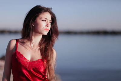 Portrait of young woman against sea