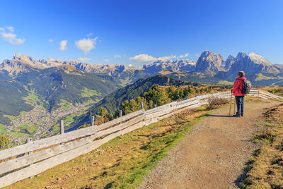 Rear view of woman standing on mountain against sky