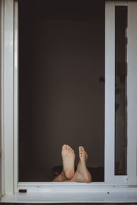 Low section of woman relaxing by window