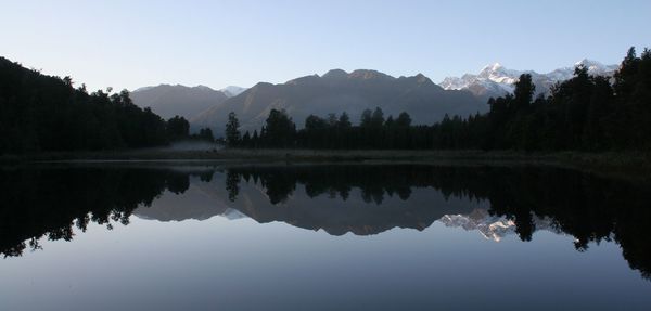 Scenic view of lake and mountains against clear sky