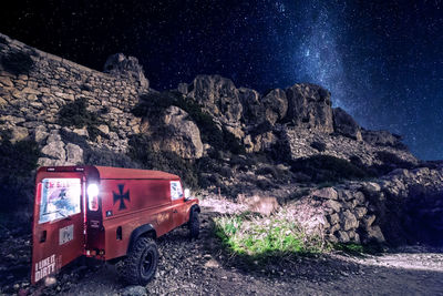 Car on mountain road against sky at night