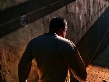 Rear view of man standing against building