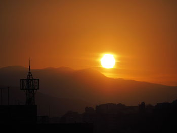 Silhouette buildings against sky during sunset