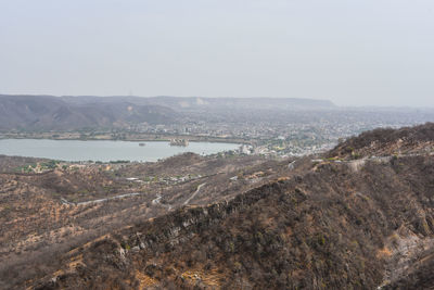 Aerial view of city by sea against sky