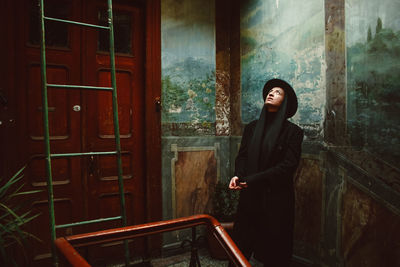 Woman wearing black clothes against wall