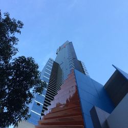 Low angle view of modern buildings against clear blue sky