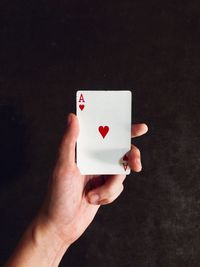 Close-up of hand holding ace of hearts