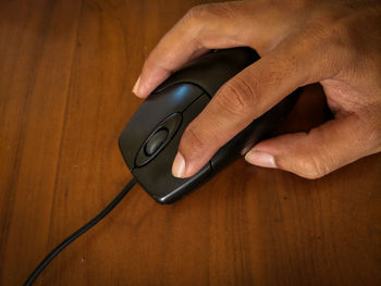 High angle view of man holding camera on table