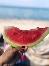 Cropped hand holding watermelon slice