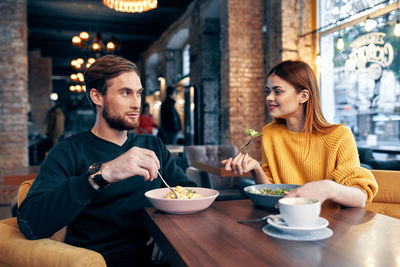 Young couple sitting on table at restaurant