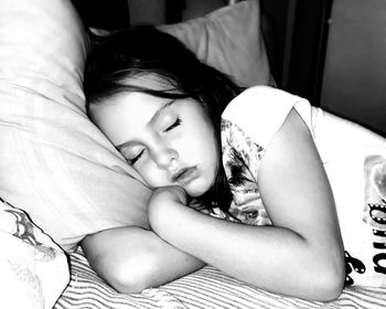 High angle view of girl sleeping on bed at home