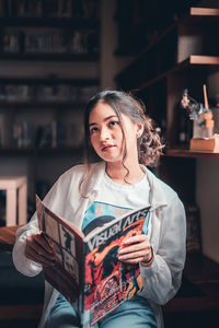 Portrait of young woman reading book