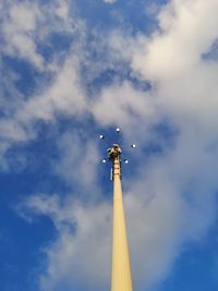 Low angle view of communications tower against cloudy sky