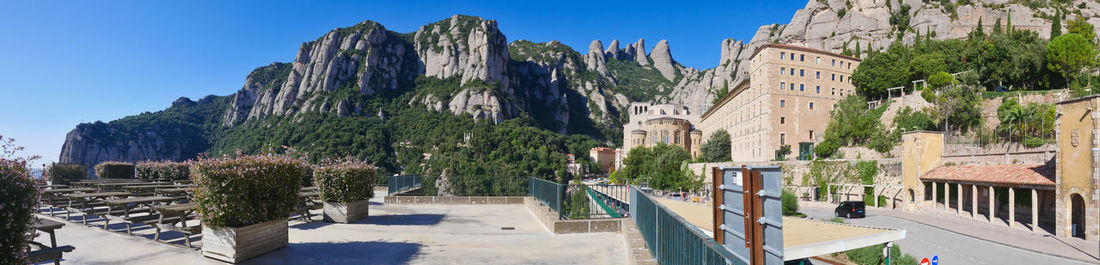 Panoramic view of trees and buildings against blue sky