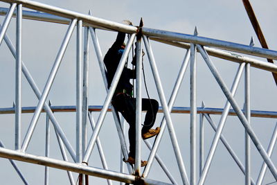 Rear view of man working on metal structure