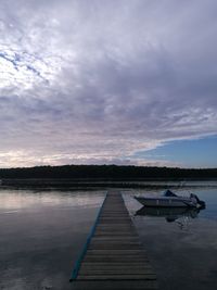 Pier over lake against sky during sunset