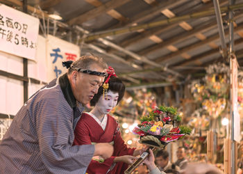 Midsection of woman holding flowers in market