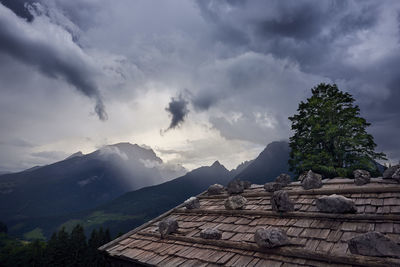 Scenic view of mountains against stormy clouds