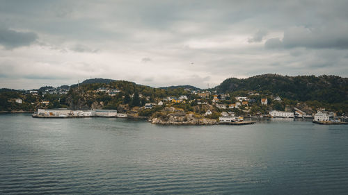 Scenic view of sea by buildings against sky