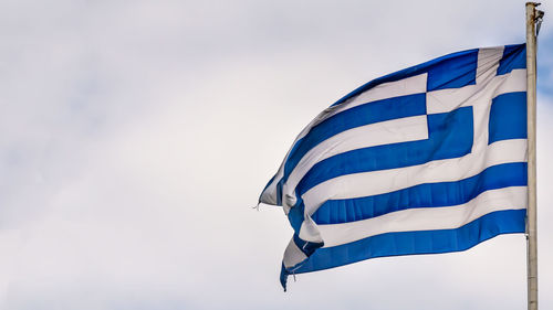 Low angle view of flags against blue sky