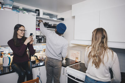 Friends enjoying in kitchen at college dorm