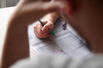 Cropped hand of man working at home