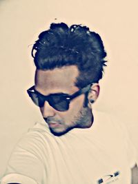 Portrait of young man looking away against white background