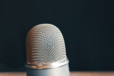 Close-up of electric lamp on table against black background