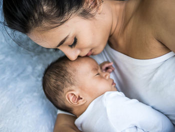 High angle view of mother and son sleeping on bed at home