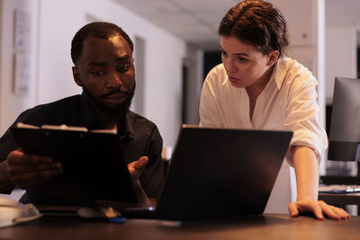 Side view of man using laptop at office