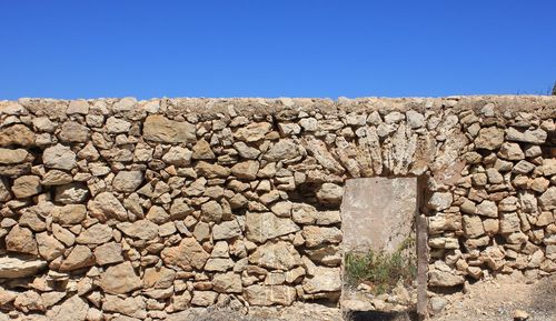 Stone wall against clear blue sky