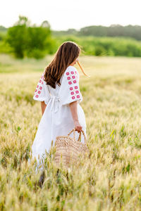 Rear view of woman standing on field