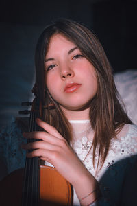 Portrait of beautiful young woman holding violin