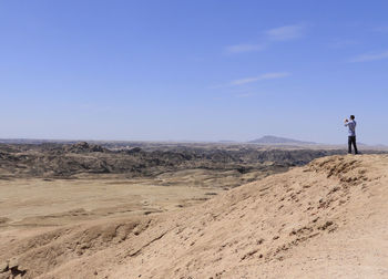 Man standing on land against clear sky
