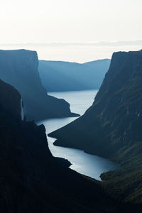 Scenic view of sea and mountains against sky in gros morne national park, newfoundland, canada