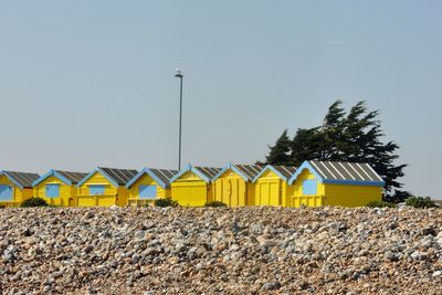 Row of beach huts against clear sky