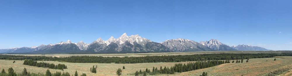 Panoramic view of landscape and mountains against blue sky