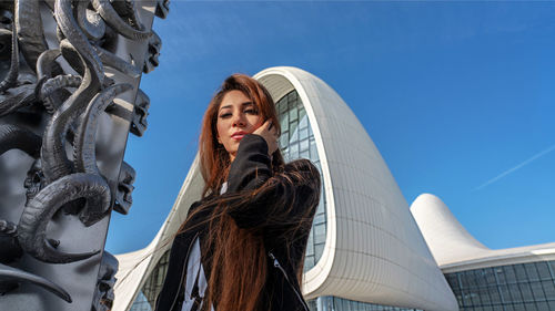 Low angle view of woman looking at sculpture